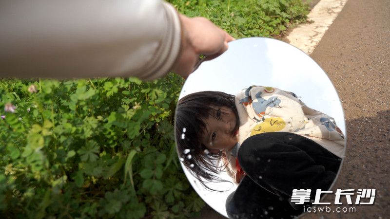 江背镇五福村，一个小女孩正对着镜子微笑。长沙晚报全媒体记者 刘晓敏 摄