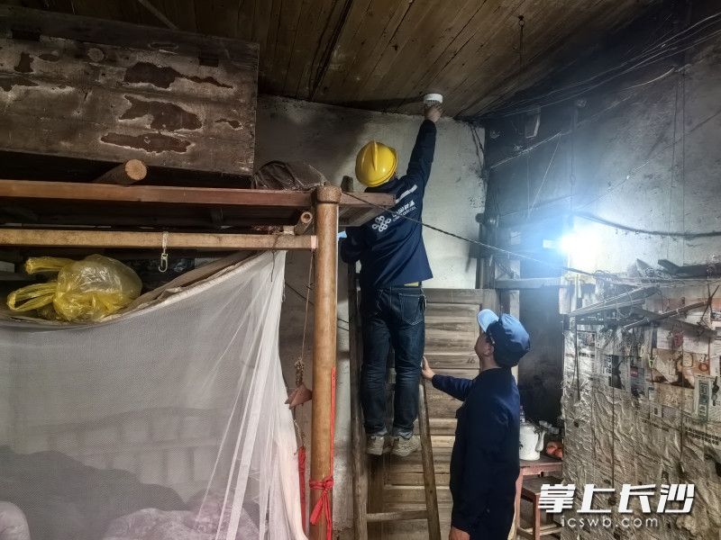 工作人员和“火焰蓝”一起为老人家中按照智慧烟感报警器。长沙晚报通讯员 寻艳 供图