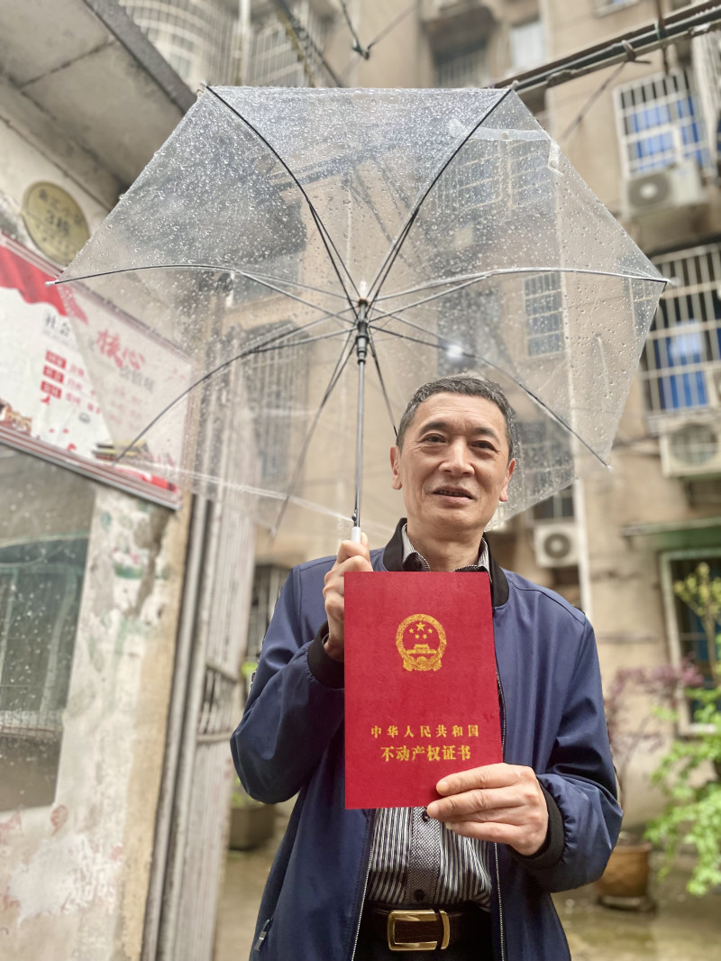 业主代表欣喜地展示姗姗来迟的房产证。 均为长沙晚报全媒体记者 李卓 摄