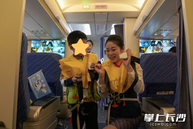 模拟机舱中，空乘人员向孩子介绍机上设备。长沙晚报全媒体记者 何文瑞 摄