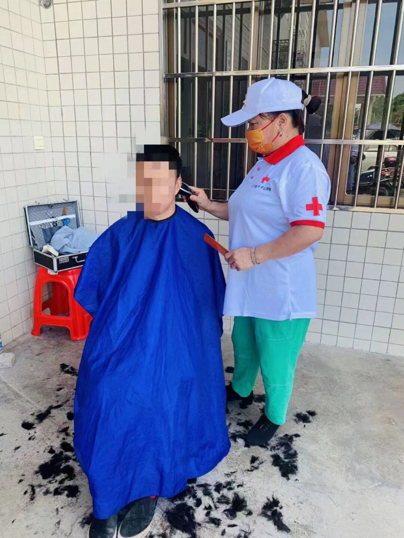 许冬花为居民义务理发。受访者供图 许冬花为居民义务理发。受访者供图