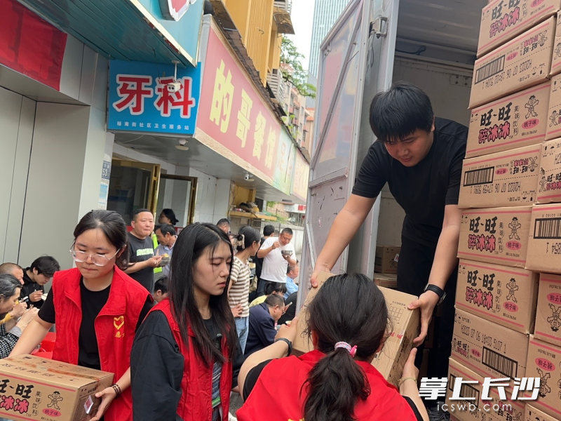 志愿者忙碌地分发物资，确保每份爱心都能准确送达。长沙晚报全媒体记者颜家文 摄