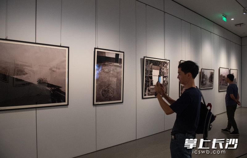 4月26日，“光影新河星城梦——纪实摄影家罗斯旦作品展”在长沙博物馆展出，市民正在观看展览。
