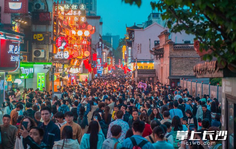 5月1日傍晚，太平老街人流如织，游客们边逛边吃。  均为长沙晚报全媒体记者邹麟摄