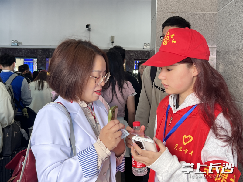 “红火炬”志愿者正在服务旅客。