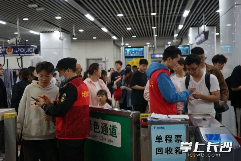 地铁工作人员有序引导乘客，并回答问询。