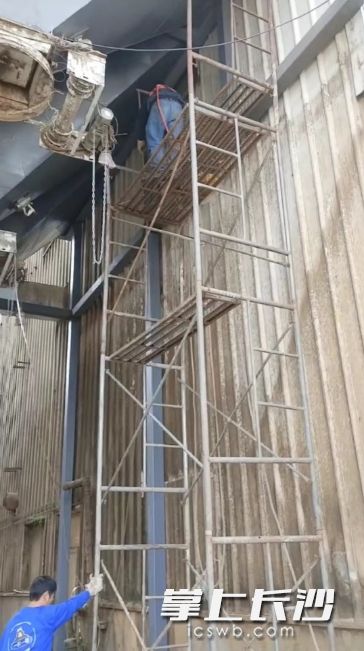 该公司高空作业人员正准备爬下脚手架。通讯员供图