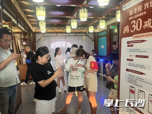 兴业银行长沙湘府路支行工作人员在杜甫江阁推广数字人民币。