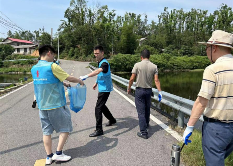 党员志愿者在捡拾河道附近的垃圾。