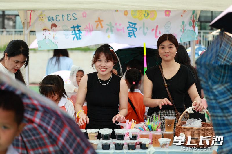 草坪的不远处，20个“爱心义卖”摊位一字排开。