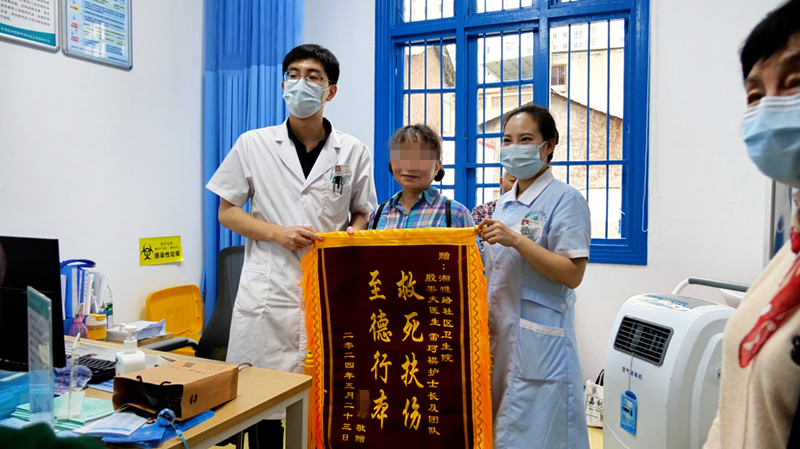 骆女士给湘雅路街道社区卫生服务中心医护人员送来锦旗，表达感激之情。