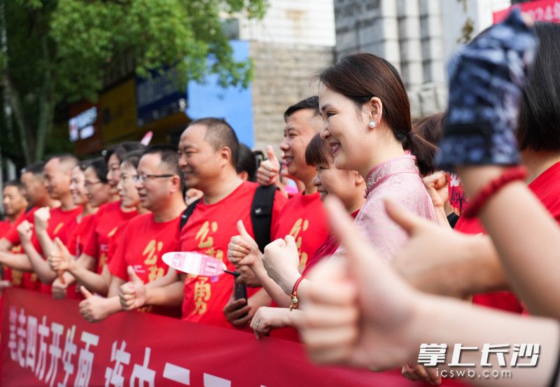 湖南师大附中考点外，考场外家长们纷纷竖起大拇指为考生点赞加油。