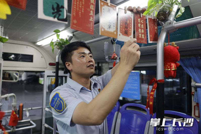 驾驶员正在车厢内悬挂写着励志词句的卡片。 长沙晚报通讯员 樊轩 供图