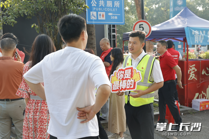 志愿者在高考考点旁开展志愿服务。  长沙公交集团供图