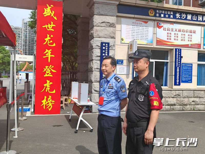 杨海卫（左）在考点外执勤，女儿在考场内考试。  长沙晚报全媒体记者 邓艳红 摄