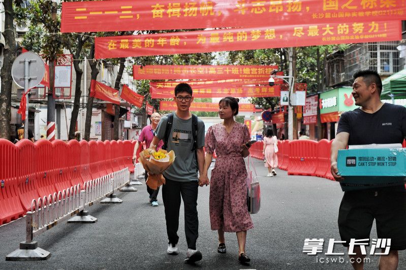 高考结束后，一位家长紧紧牵着孩子的手回家。