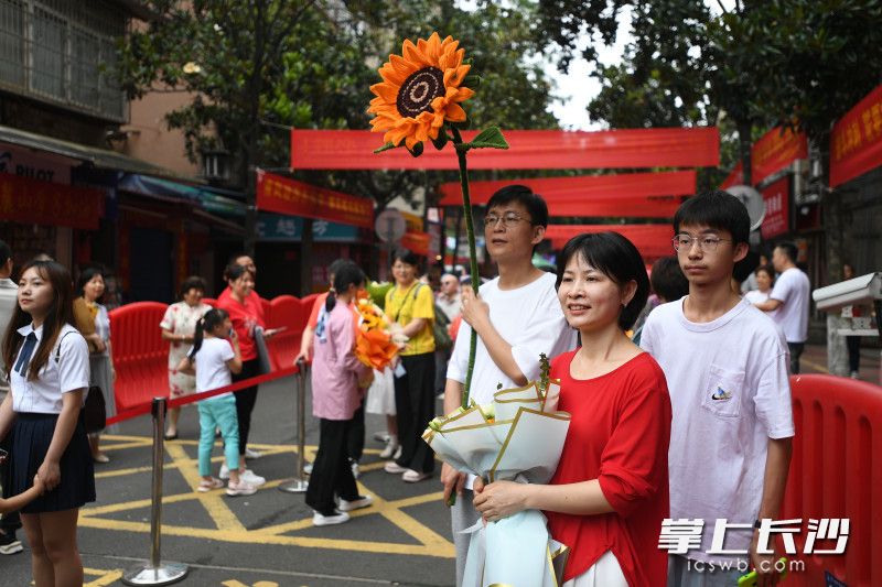 家长们手捧鲜花等待孩子们散考。