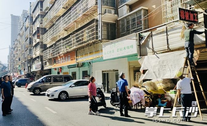 拆除遮挡逃生通道的防盗窗网和广告牌。 长沙晚报通讯员 汤银 供图