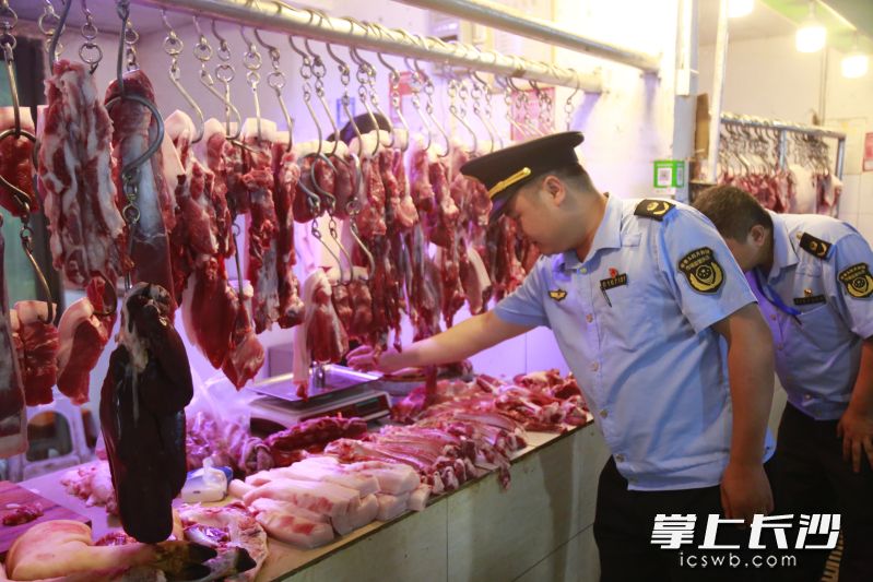 市场监管执法人员在对经营户的电子秤具进行检查。 均为长沙晚报通讯员宇薇供图