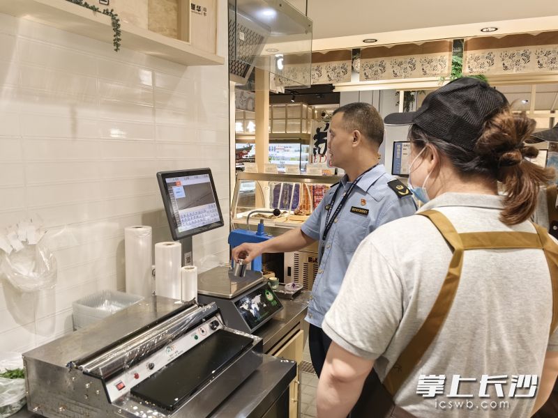 市场监管部门在对经营户的电子秤具进行检查。