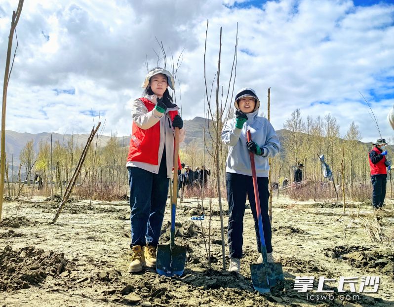 高亚琼（左一）与当地居民在雅江河畔志愿植树。资料图片