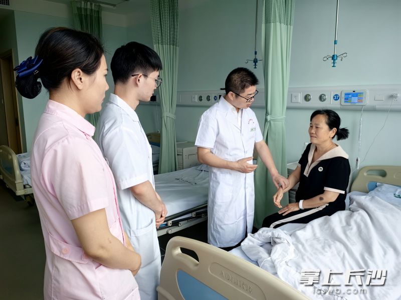 医护人员在病房了解军属鲁阳英的身体情况。