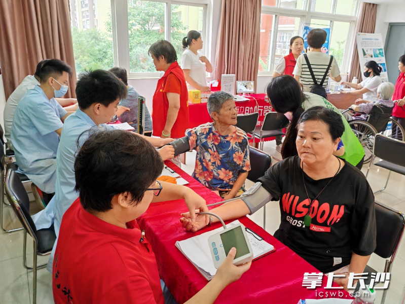 数十名群众正在接受免费口腔检查、血压测量、听力检测、中医问诊、推拿、骨科检测等医疗服务。