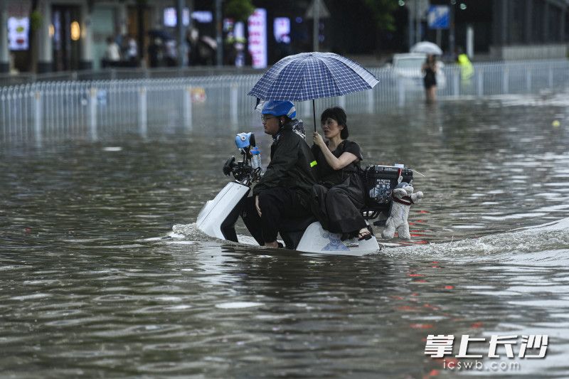 6月24日14时33分，芙蓉区车站中路长沙火车站钱，一位外卖小哥载着一位旅客通过积水路面。