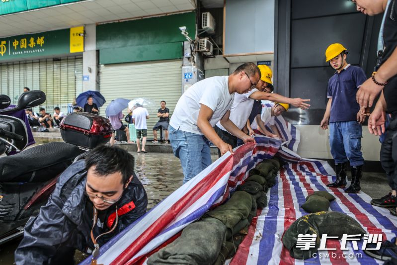 在长沙火车站地铁站的一个出入口，工作人员正在进行隔挡，防止积水灌进。  均为长沙地铁供图