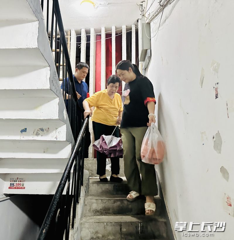 暴雨天气下工作人员连夜帮老人撤出危房。