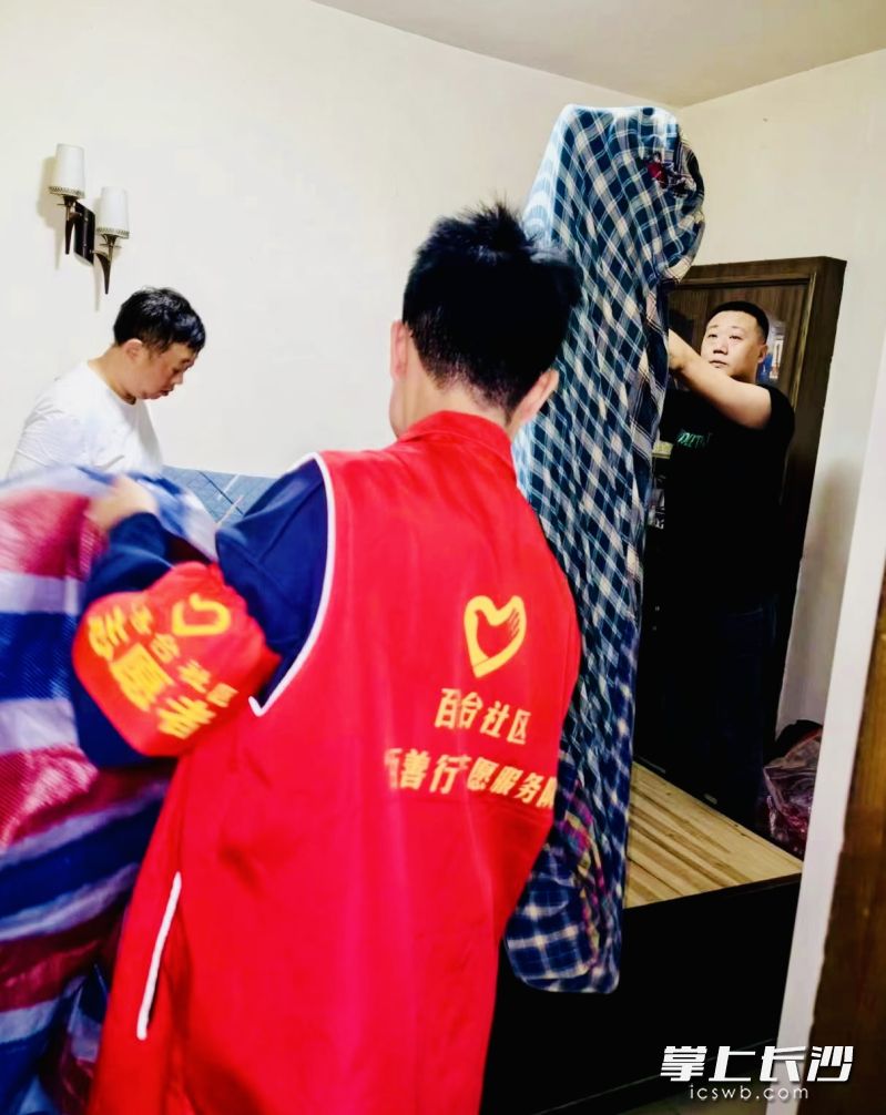 社区志愿者帮助危房住户搬离。