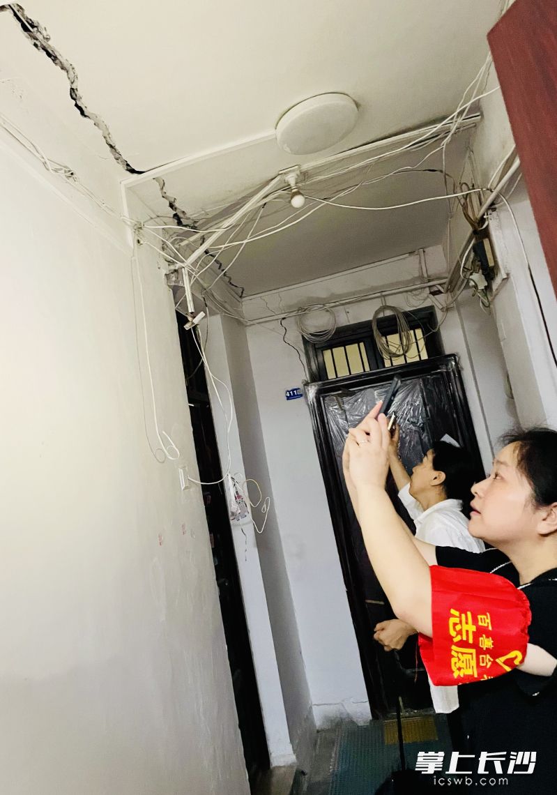 社区工作人员在现场勘查布满裂纹的危房。 均为长沙晚报全媒体记者 李卓 摄