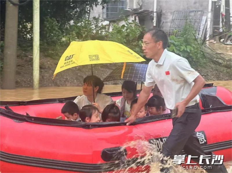 浏阳市高坪镇纪委干部在太坪村新希望幼儿园转移被洪水围困的学生。  长沙晚报通讯员 郭亚芸 供图