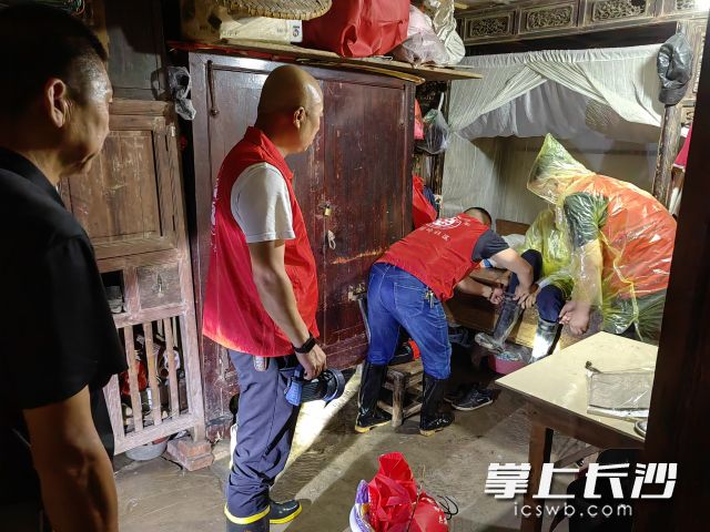 暴雨之夜，邻长唐日辉与社区工作人员、志愿者将生病的盲人五保户送至医院。 长沙晚报通讯员 秦晓阳 供图