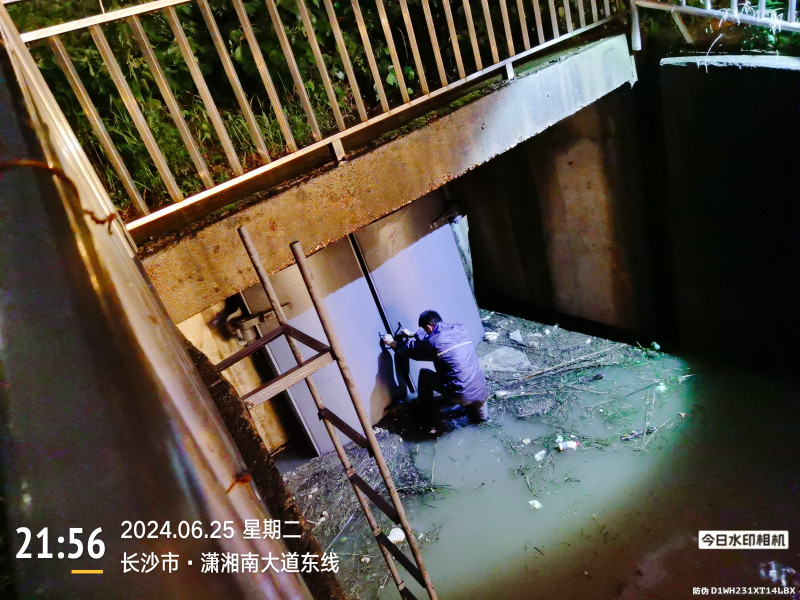 张松山发现闸门异常，衣服一脱就扎进水里进行排险。