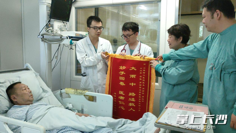 蔡大爷的老伴龚奶奶和儿子将锦旗交到医生手中。 长沙晚报全媒体记者 徐媛 实习生 谭仕兰 摄 蔡大爷的老伴龚奶奶和儿子将锦旗交到医生手中。 长沙晚报全媒体记者 徐媛 实习生 谭仕兰 摄
