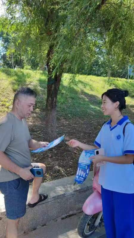 一名学生向行人发放法治宣传单。