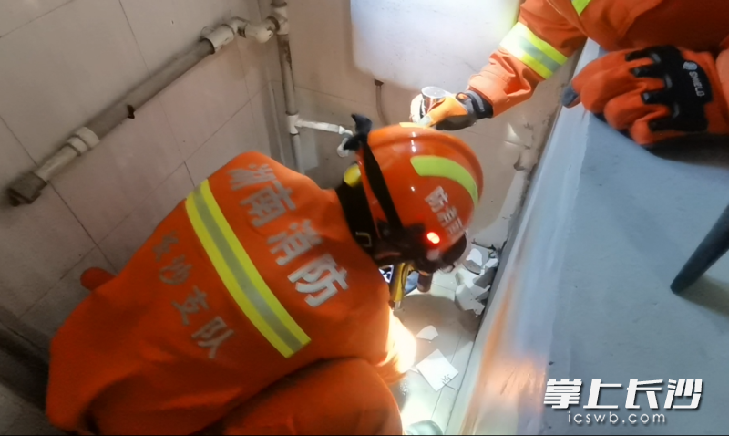 消防救援人员小心翼翼地使用锤子和手动破拆工具组对厕所进行破拆。长沙晚报通讯员 寻艳 供图