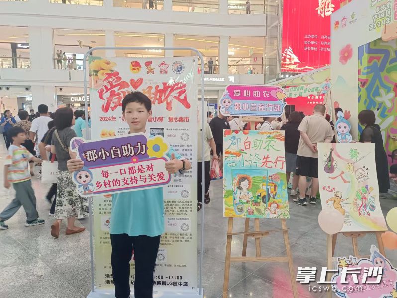 一名“雷小锋”在展示学校的宣传广告牌。