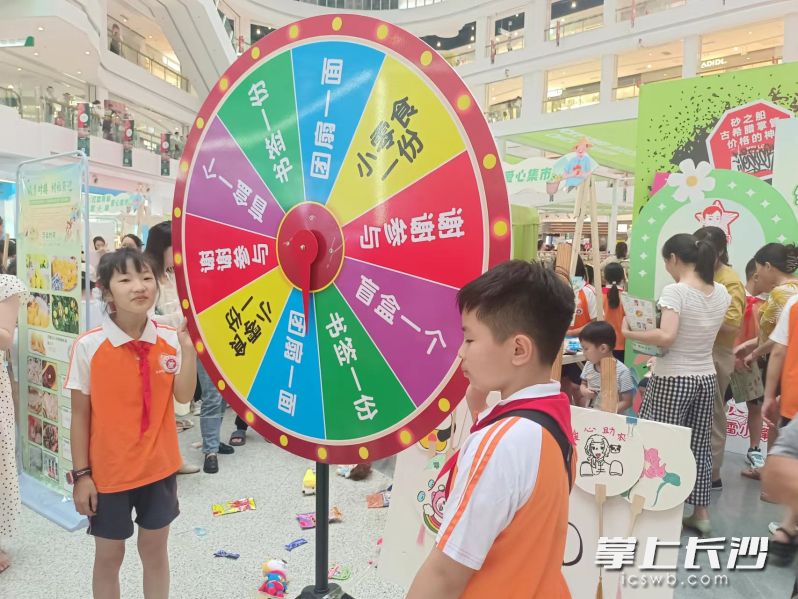 长郡月亮岛第三小学的“雷小锋”为吸引顾客，推出“购买土特产可转盘抽奖”活动。