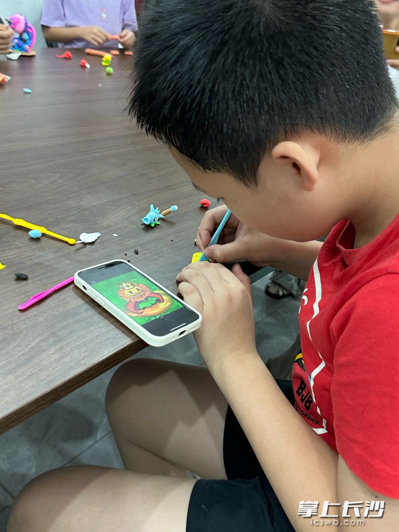 一位小孩在做手工活。长沙晚报全媒体记者 邓艳红 摄