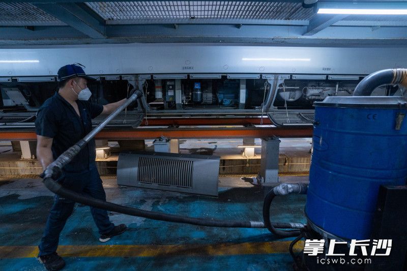 用吸尘器为设备仓除尘。