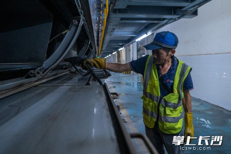 夏日高温天气为保障高速动车组列车平稳运行，机械师正在清洗设备部。