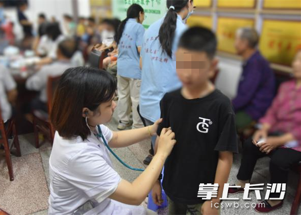 实践团的老师和大学生为当地儿童进行身体检查。 均为长沙晚报通讯员彭宇瑄、王佳乐供图 实践团的老师和大学生为当地儿童进行身体检查。 均为长沙晚报通讯员彭宇瑄、王佳乐供图