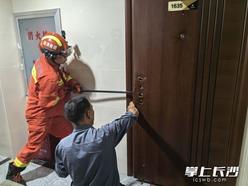 消防救援人员对房门紧急破拆中。长沙晚报通讯员 谢梦嘉 供图