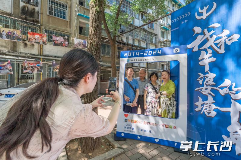 居民们在打卡板前合影留念。