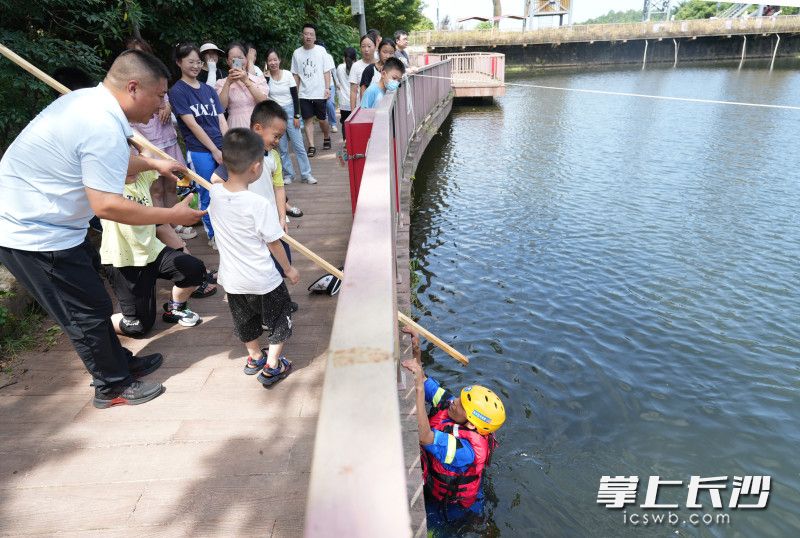 蓝天救援队队员正在湖边现场教授少年儿童如何自救和寻求大人救援。长沙晚报全媒体记者 邹麟 摄