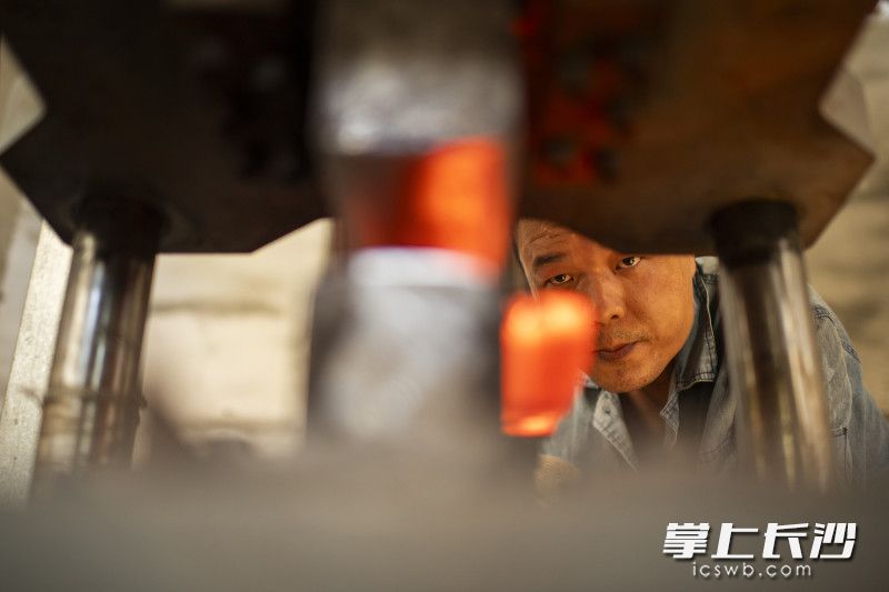 夹钢工序完成后，黄钊漪将再次烧红的刀胚取出进行锻压。不同于传统的用铁锤捶打，他借助了力度更强且可控力的现代液压机、气锤。