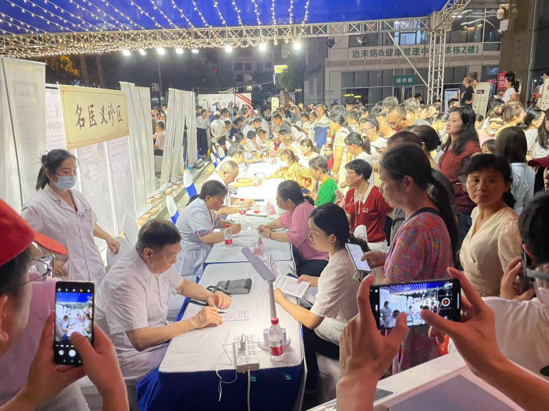 在夜市的名医义诊专区，市民有秩序地排着队等候义诊。