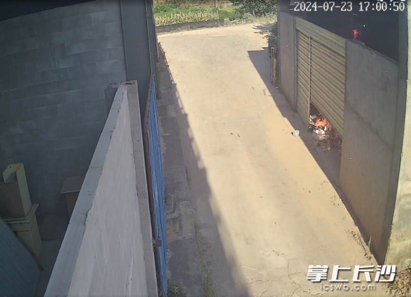 监控视频显示，男孩离开1分钟后，卷闸门东侧附近有火星掉落地面，明火逐渐扩大并冒浓烟。